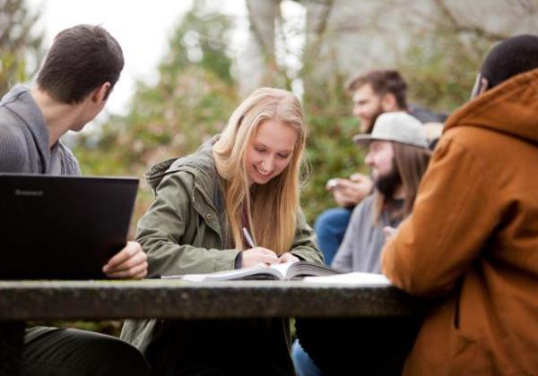 Female and male students working together outside