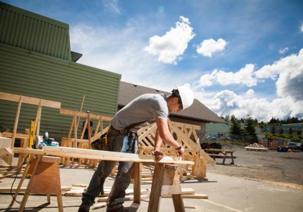 Young man working outside at a sawhorse