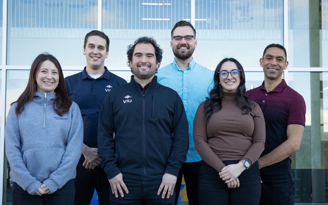 Smiling people standing together outside a building